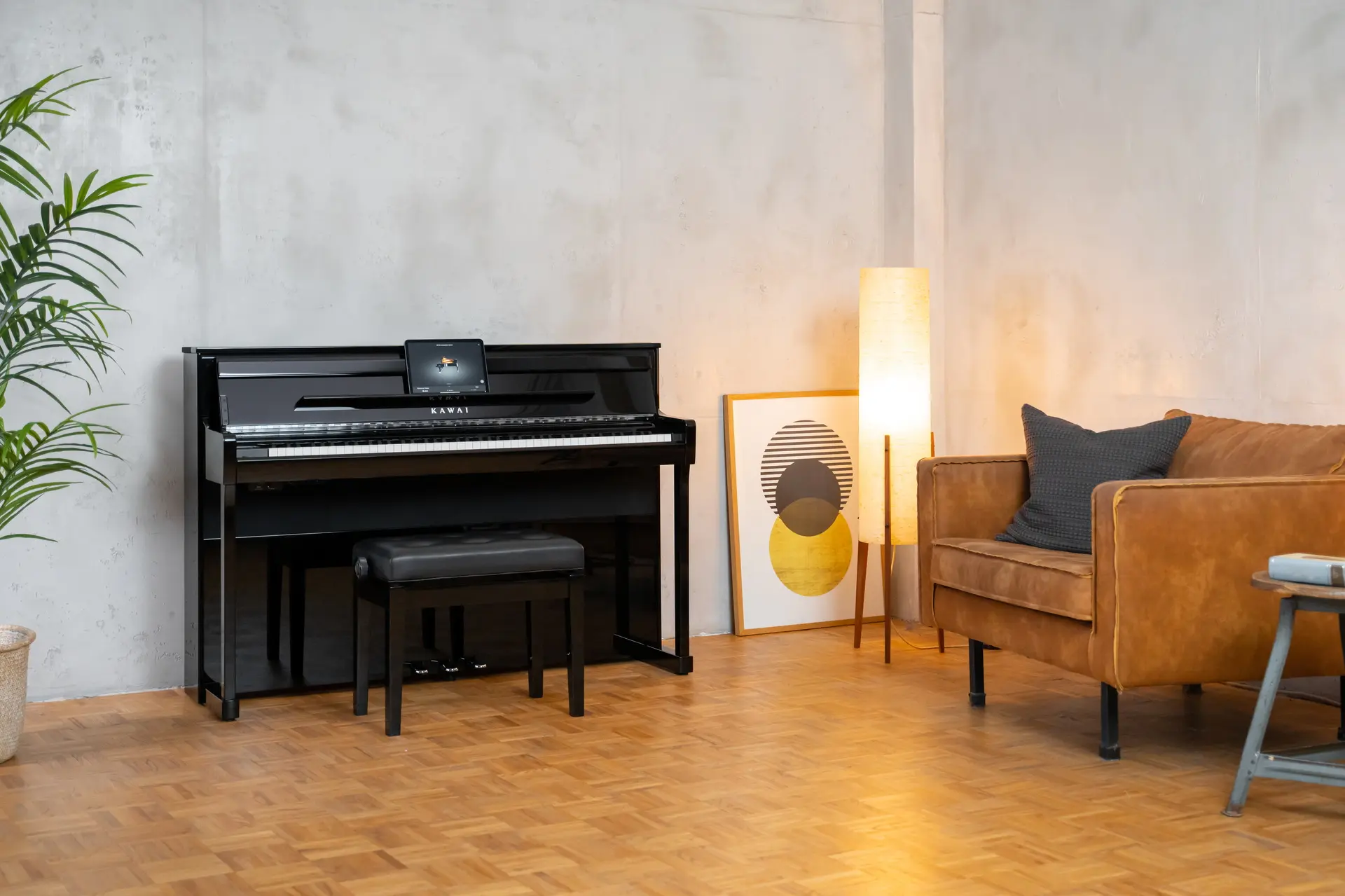 Black Kawai CA digital piano in a bright living room with an armchair and floor lamp.