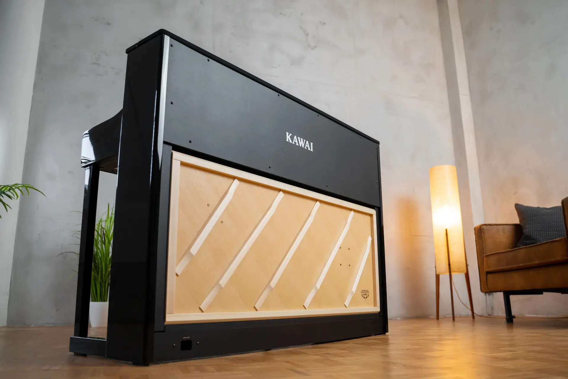 Close-up of a black Kawai CA digital piano with decorative front panel in a living room.