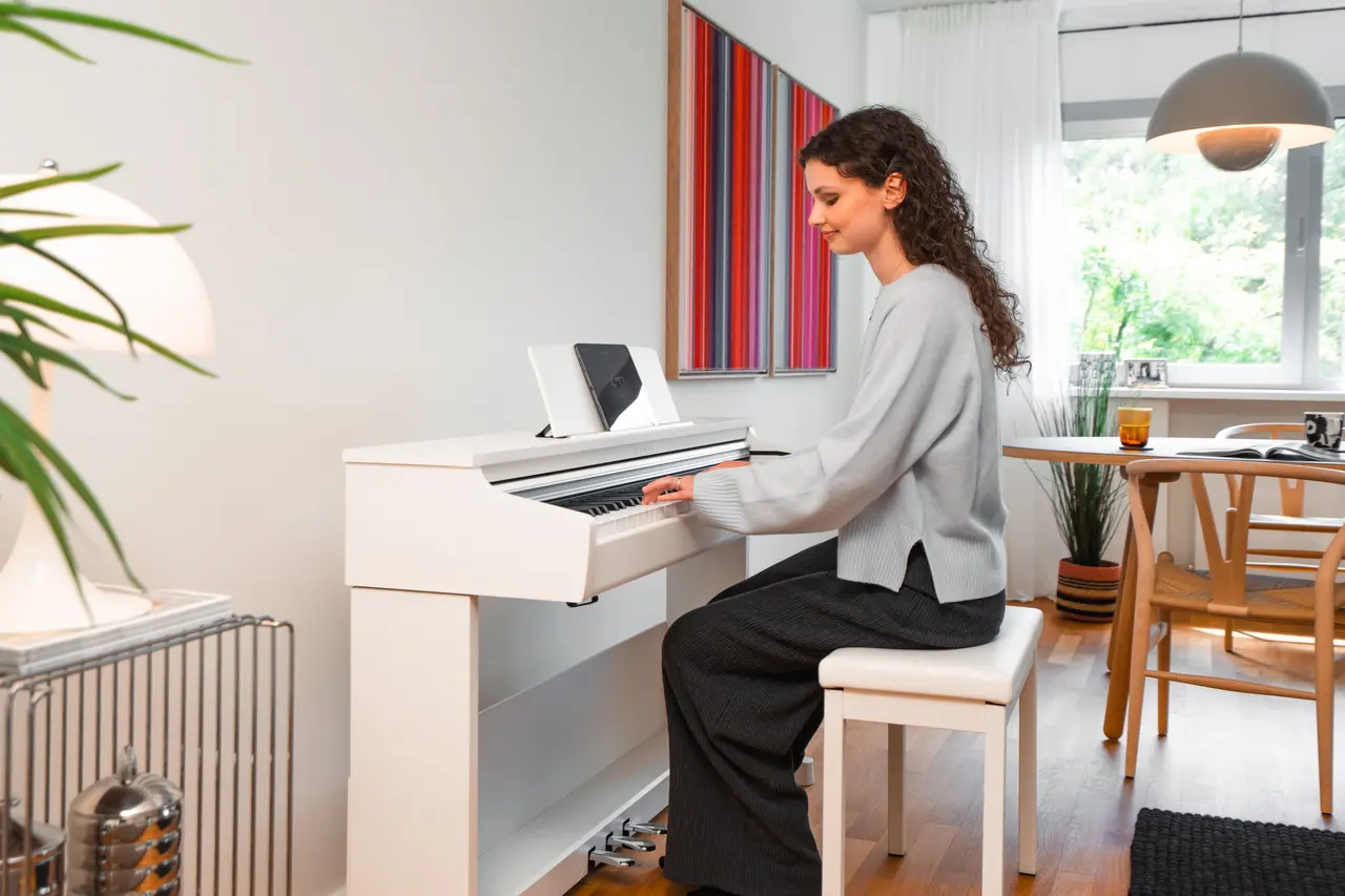 Junge Frau spielt an einem weißen Kawai CX Digitalpiano mit Tablet