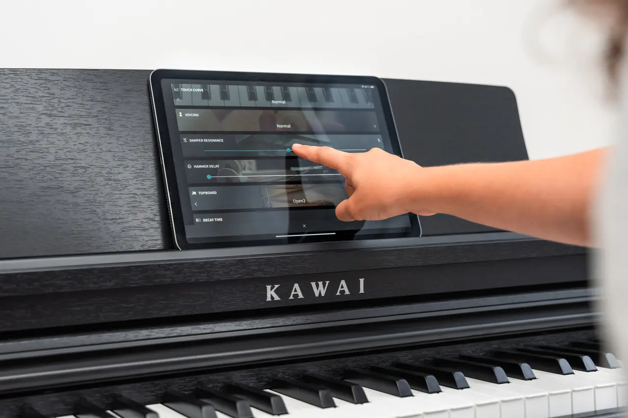 Hand bedient das Display eines schwarzen Kawai Digitalpianos.