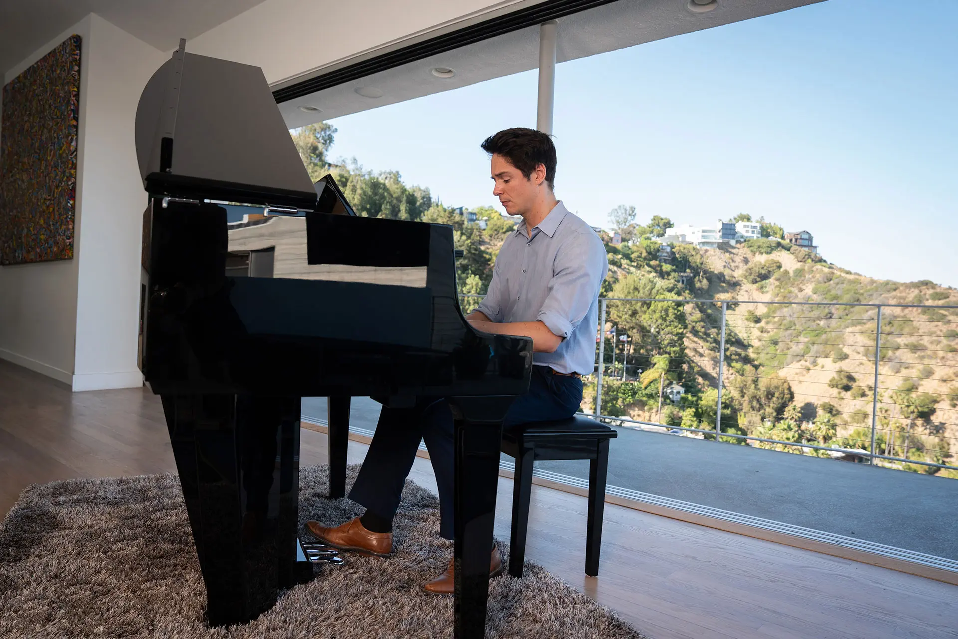 Une personne joue sur un piano hybride Kawai NOVUS dans un salon moderne