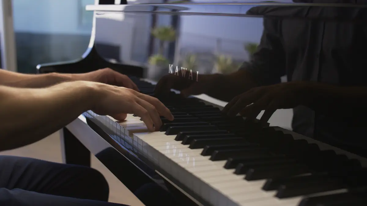 On joue du piano hybride Kawai NV12, gros plan des mains sur le clavier