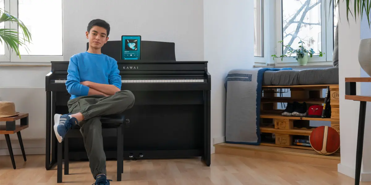 Person sitting with a tablet next to a Kawai CA 401 digital piano