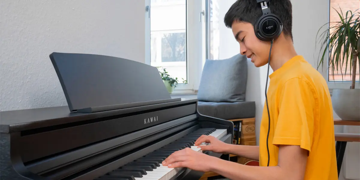 Person playing the Kawai CA 401 digital piano with headphones