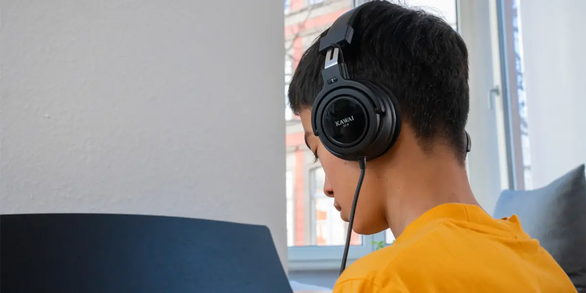 Kawai CA 401 player wearing headphones at the digital piano