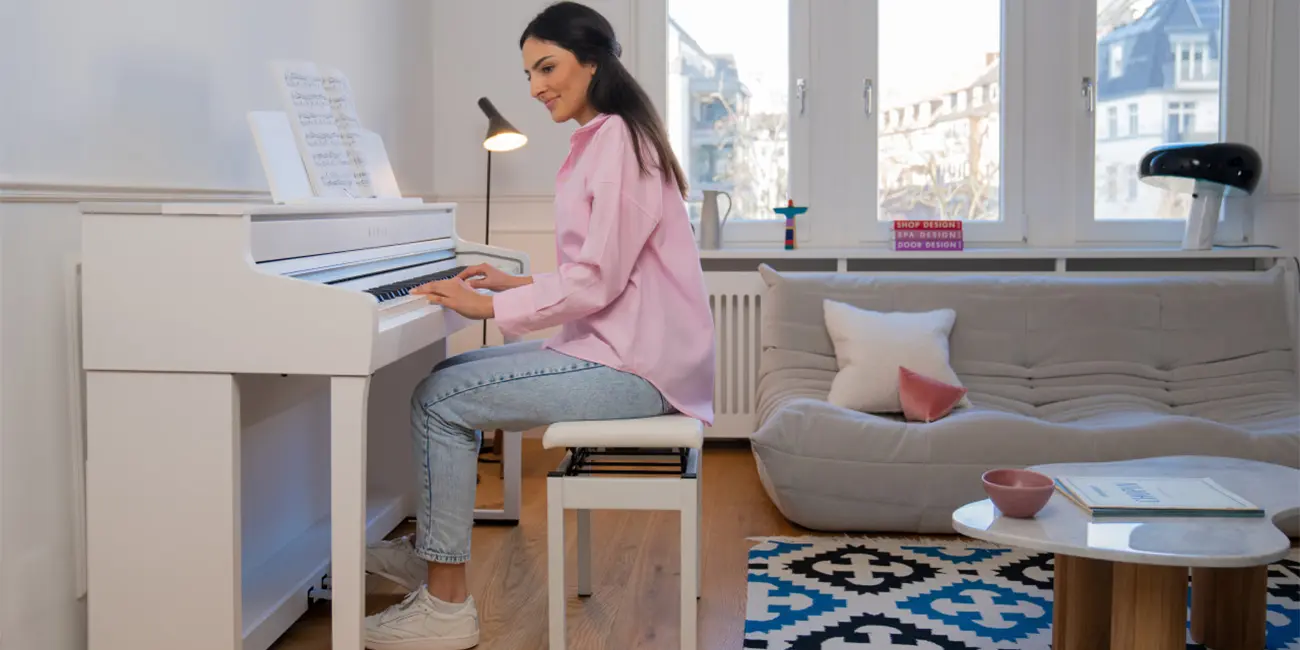 Frau spielt auf einem weißen Kawai CA501 Digitalpiano im Wohnraum