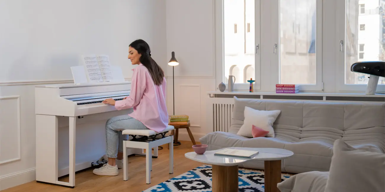 Frau spielt auf einem weißen Kawai CA501 Digitalpiano im hellen Wohnraum