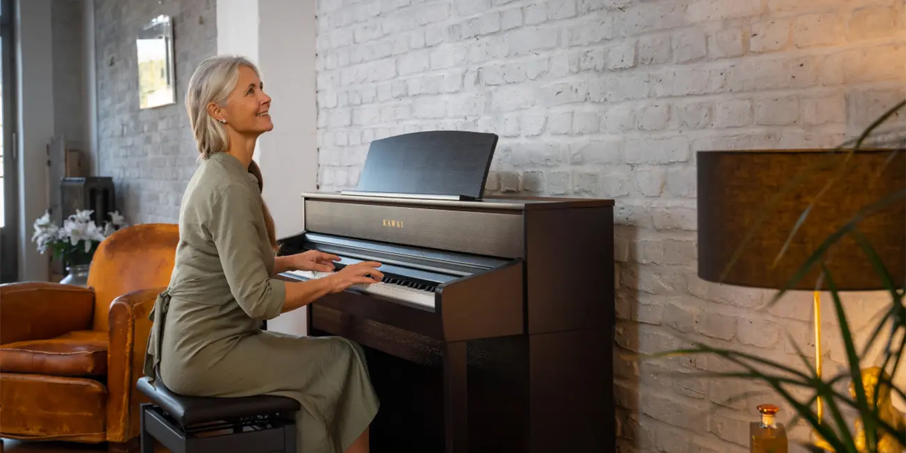 A woman plays a Kawai CA701 digital piano from the side