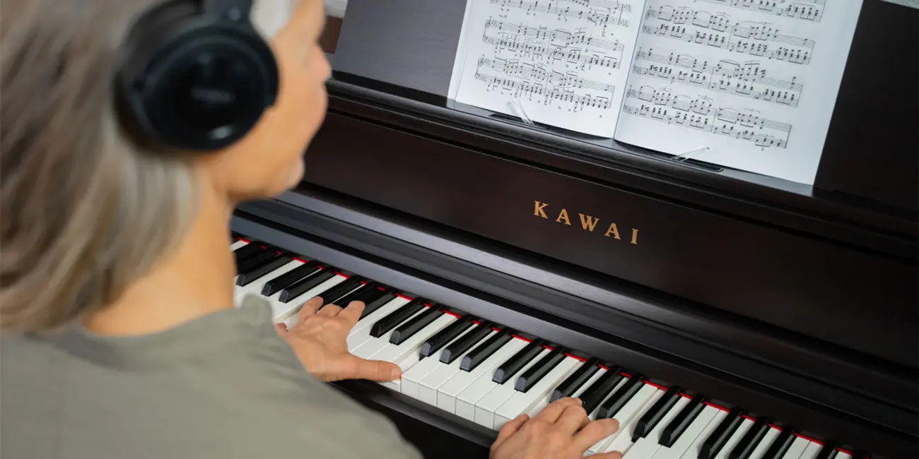 Woman playing a Kawai CA701 digital piano with headphones