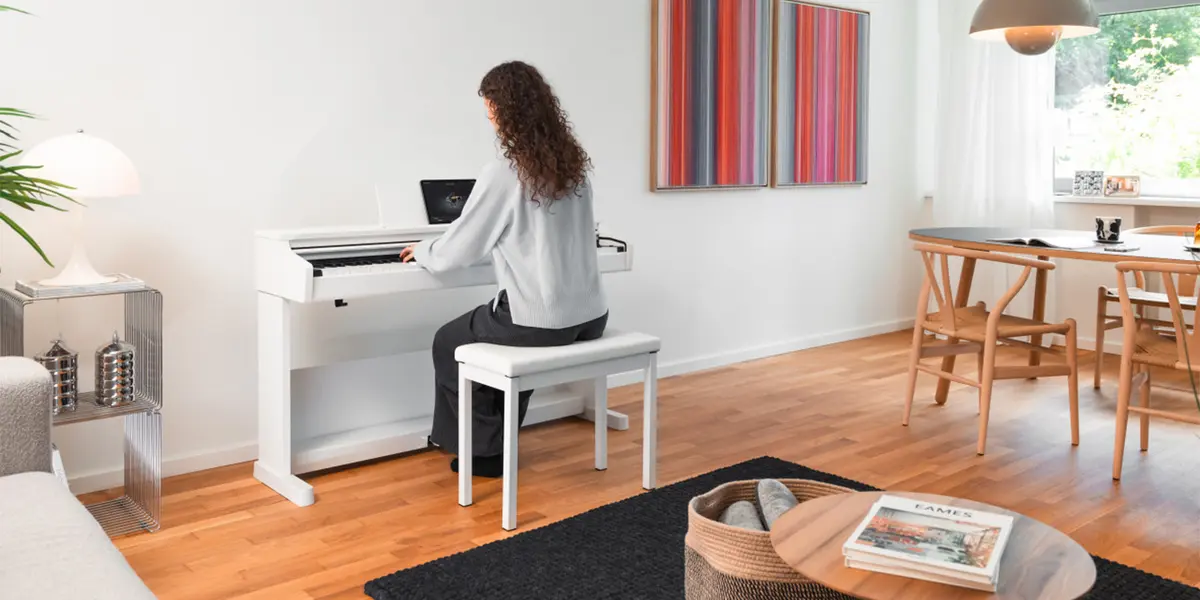 Frau spielt auf einem weißen Kawai CX102 Digitalpiano im Wohnraum