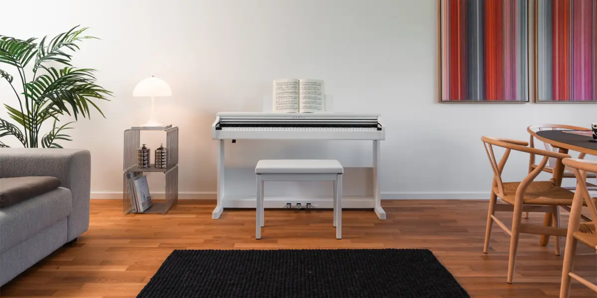 Weißes Kawai CX102 Digitalpiano in einem Wohnzimmer neben Sofa und Esstisch