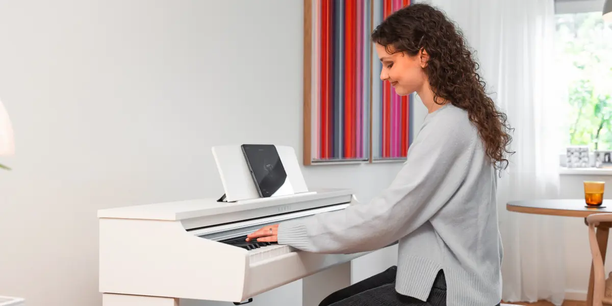 Frau sitzt an einem weißen Kawai CX102 Digitalpiano