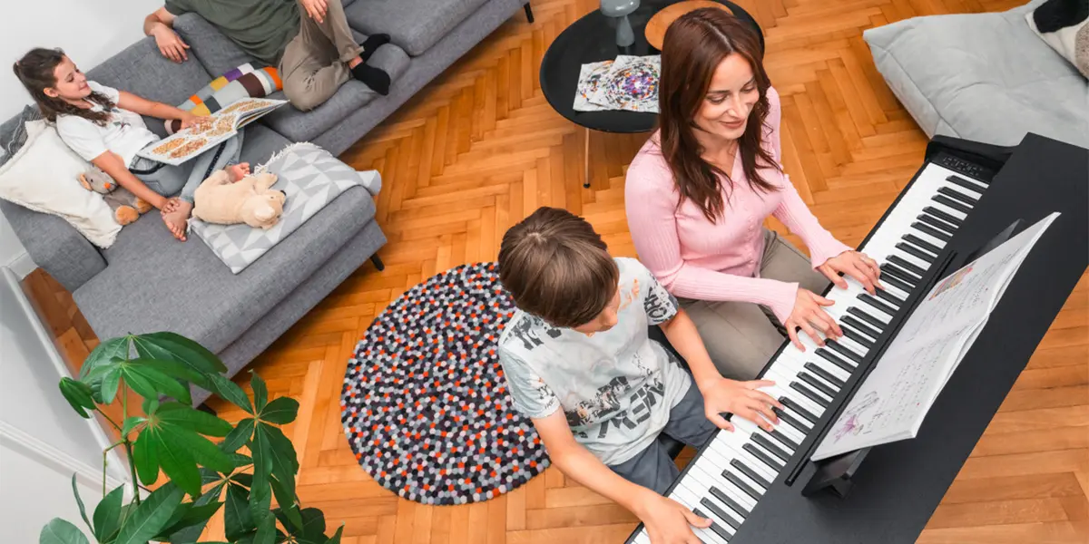 Erwachsene und Kind spielen gemeinsam am Kawai CX202 Digitalpiano