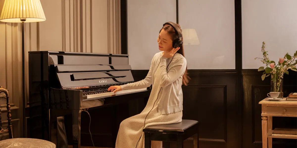 Le piano hybride Kawai NV6 est joué dans la pièce chaleureusement éclairée