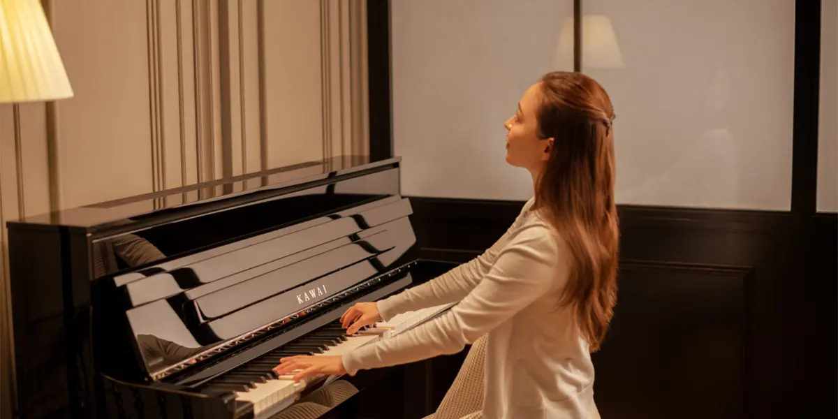 Le piano hybride Kawai NV6 est joué dans la pièce chaleureusement éclairée
