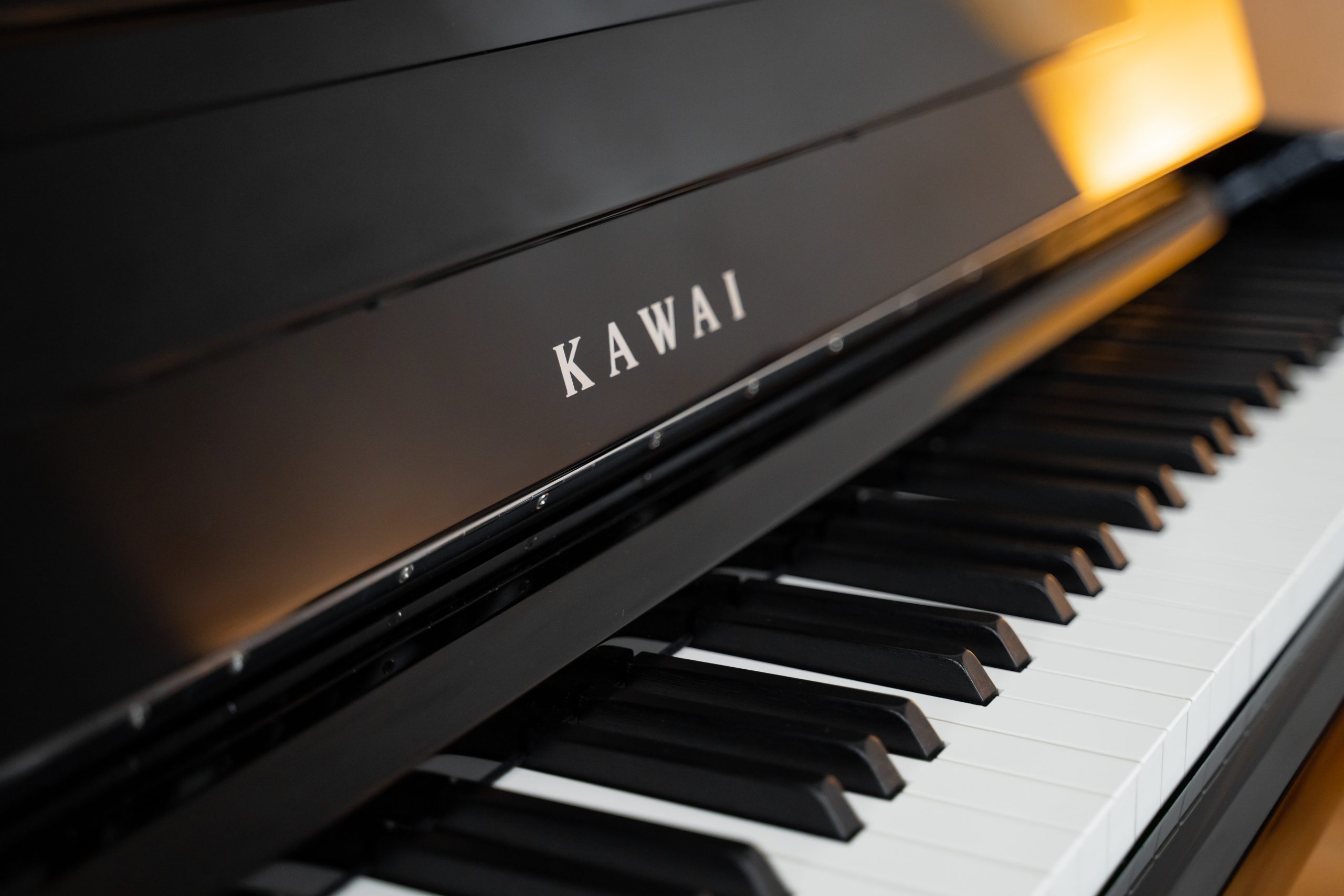 Nahaufnahme der Tastatur und des Tastendeckels des Kawai CA 901 mit Kawai-Logo