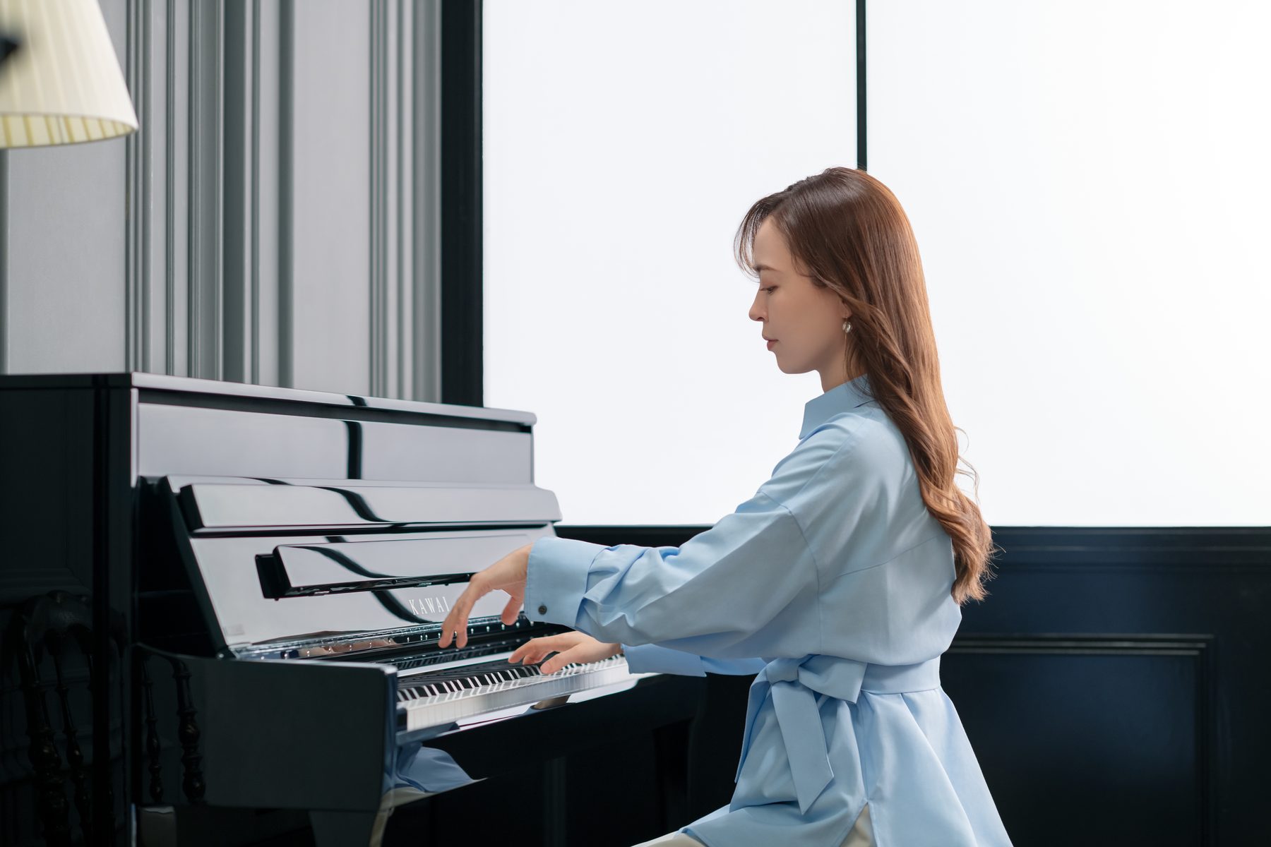 Ein Pianist spielt am Fenster an einem Kawai NOVUS NV6