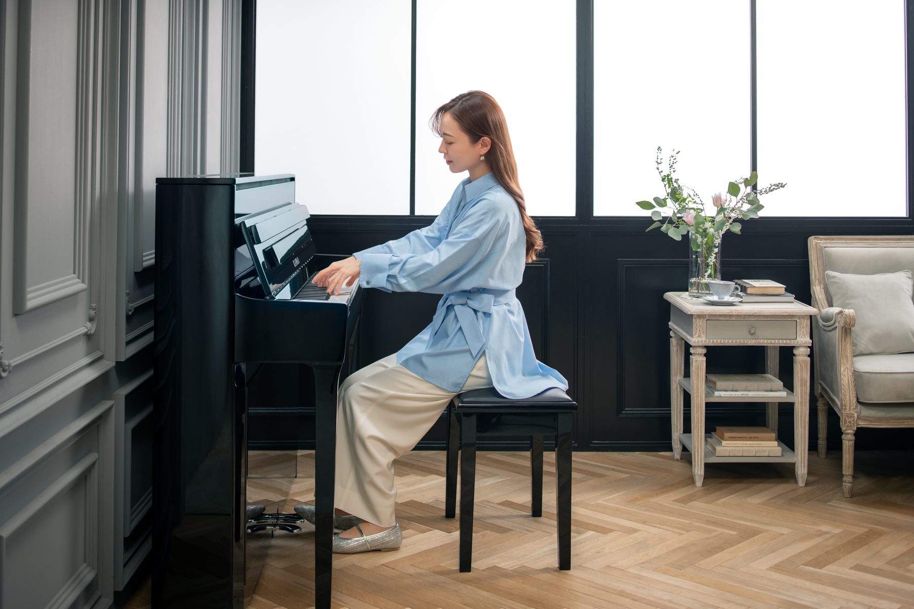 Eine Pianistin an einem Kawai NOVUS NV6 in einem hellen Wohnraum