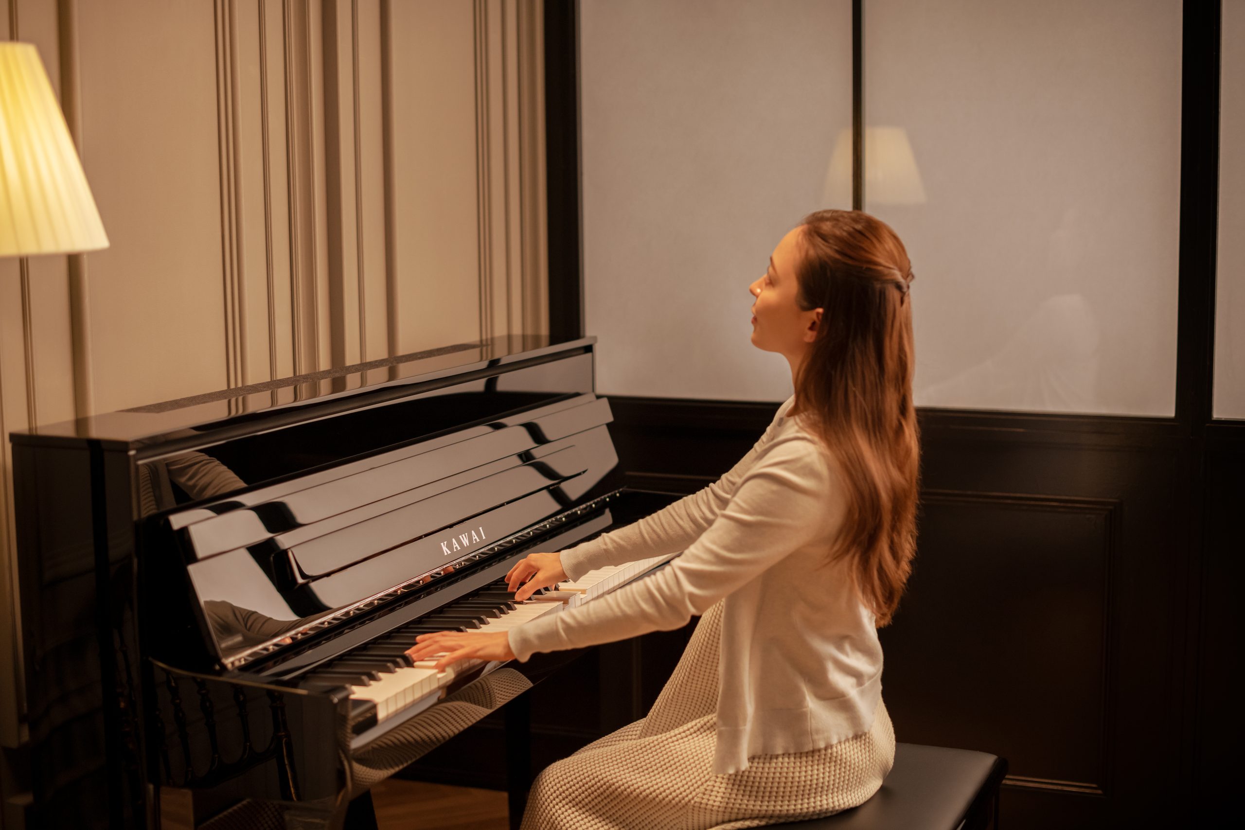 Ein Pianist spielt das Kawai NOVUS NV6 im warmen Abendlicht