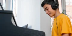 Person hört mit Kopfhörern am Kawai CA 401 Digitalpiano