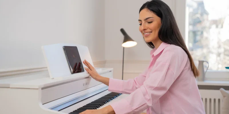 Frau spielt an einem weissen Kawai CA Digitalpiano in einem hellen Wohnzimmer