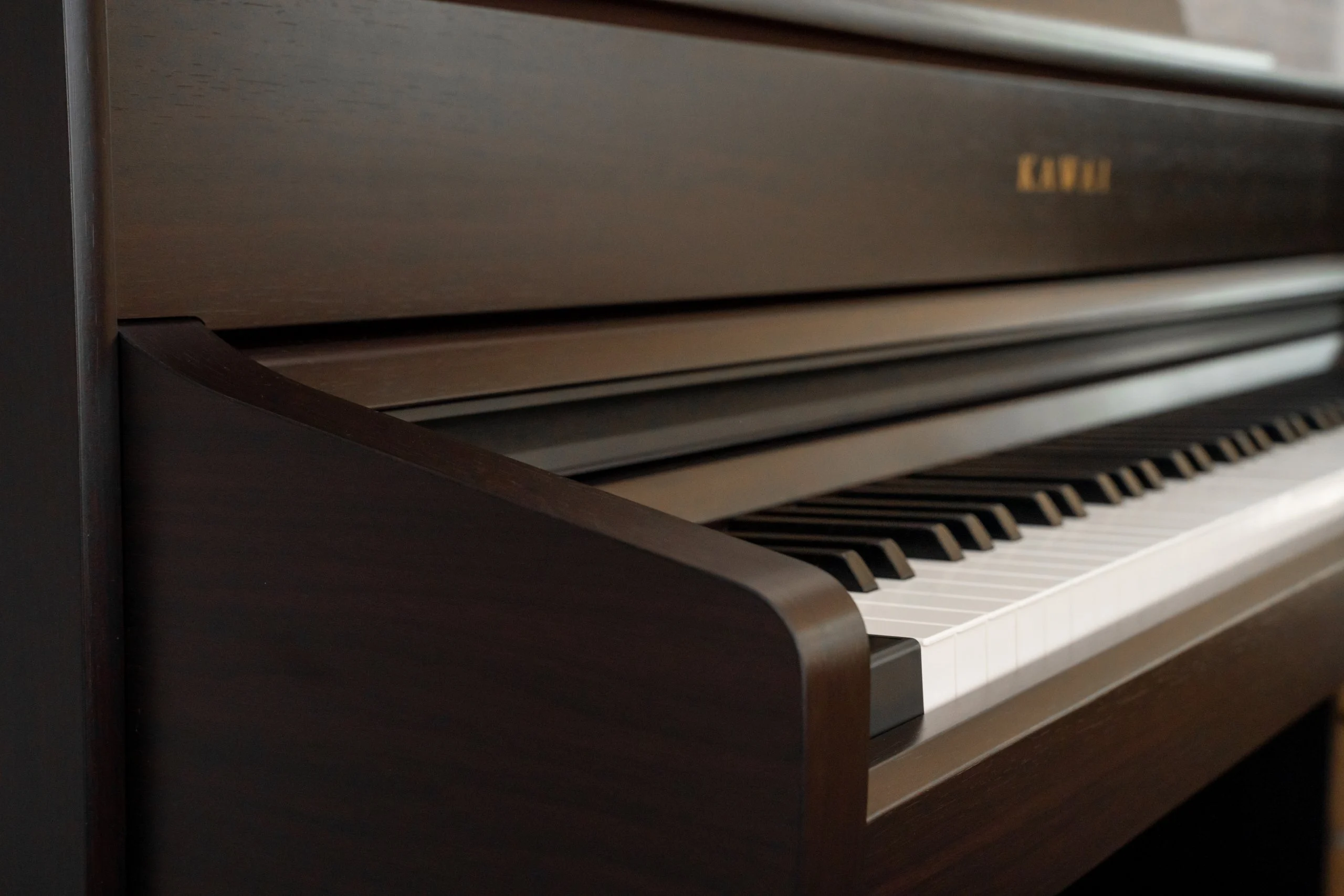 Close-up of the Kawai CA 701 keyboard and fallboard with the Kawai logo