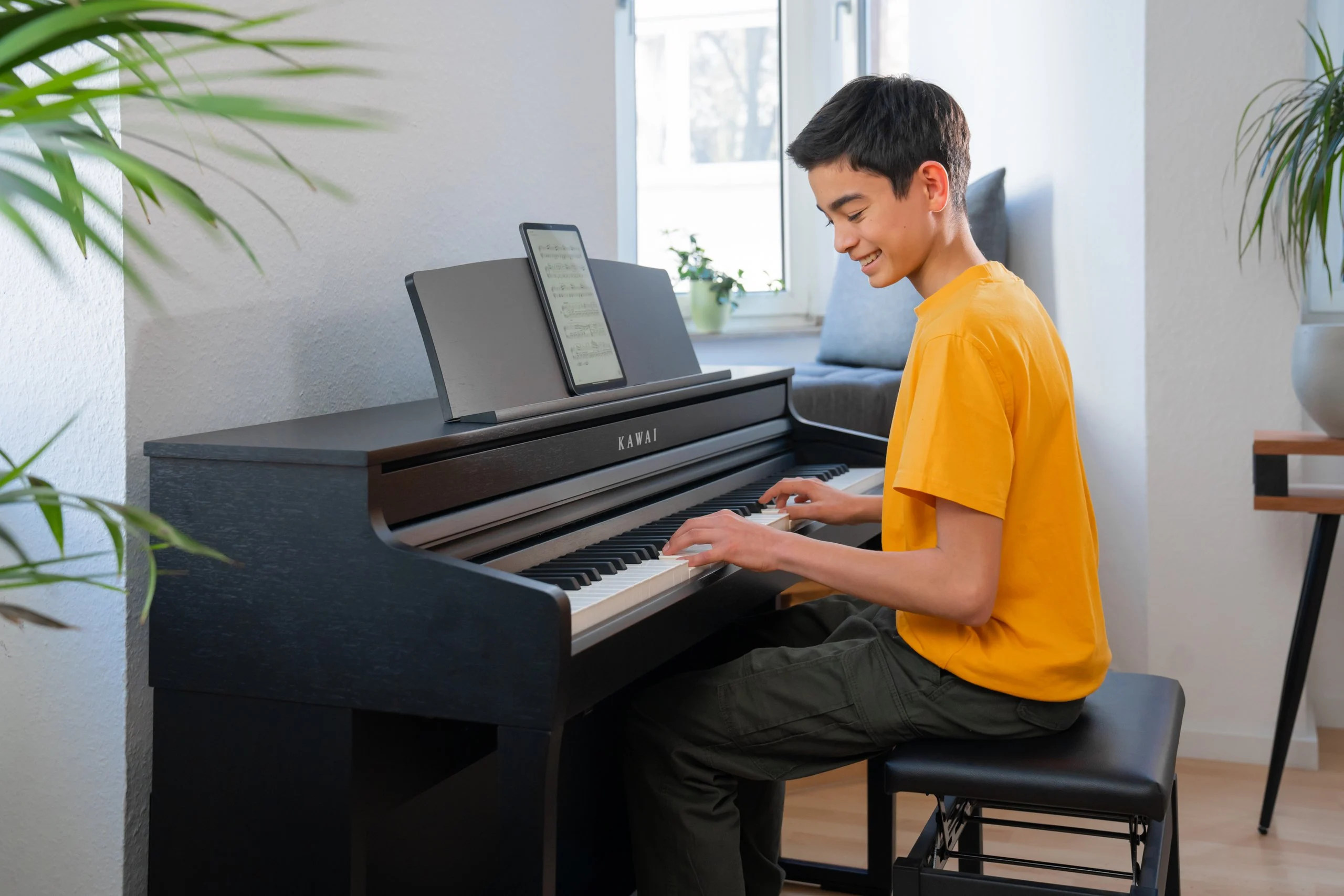 A young man playing the Kawai CA 401 in a bright living room