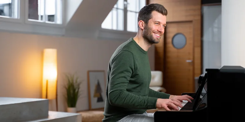 Mann spielt konzentriert an einem schwarzen Kawai CA Digitalpiano